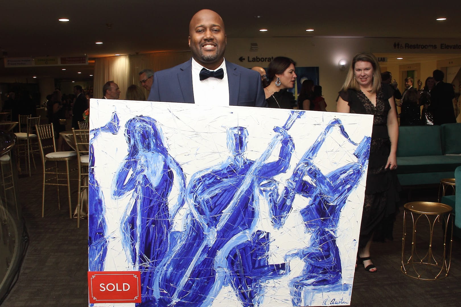 Artist stands with sold painting